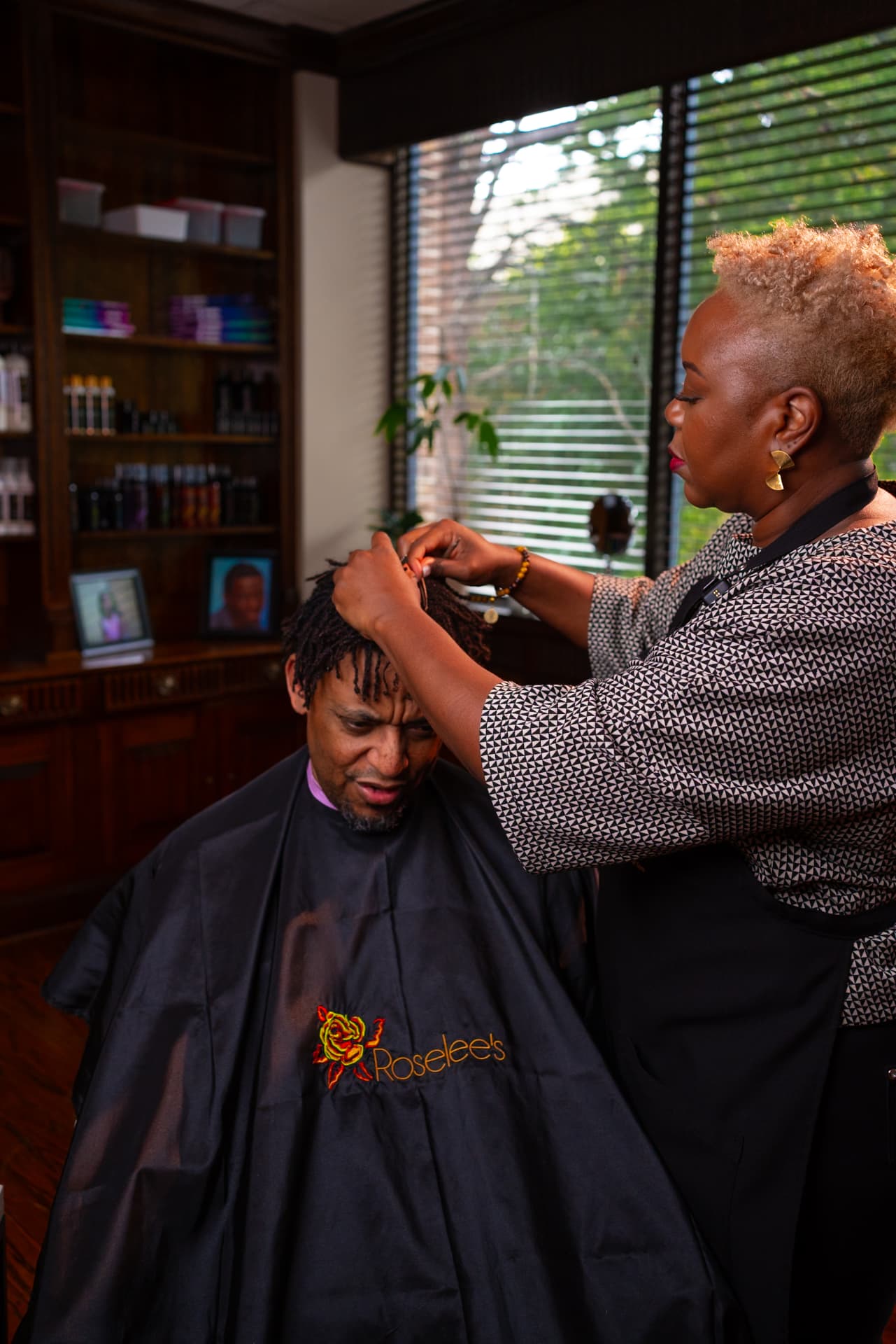 Loctician working with precision on a client in a professional studio